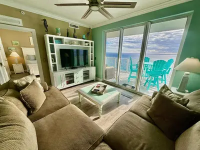 a living room with a couch and a view of the ocean at Tropic Winds 2209 in Panama City Beach