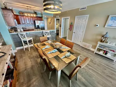 a dining room and kitchen with a table and chairs at Tropic Winds 2209 in Panama City Beach