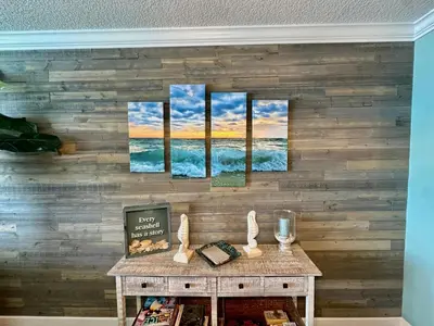 a wall with four paintings of the ocean at Tropic Winds 2209 in Panama City Beach