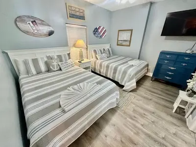 a bedroom with two beds and a dresser at Tropic Winds 2209 in Panama City Beach