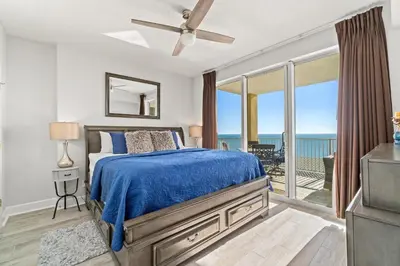 a bedroom with a bed and a view of the ocean at Tropic Winds 1901 in Panama City Beach