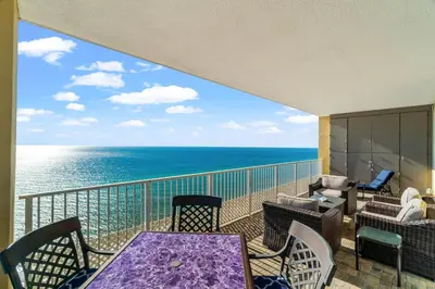a balcony with a table and chairs and the ocean at Tropic Winds 1901 in Panama City Beach