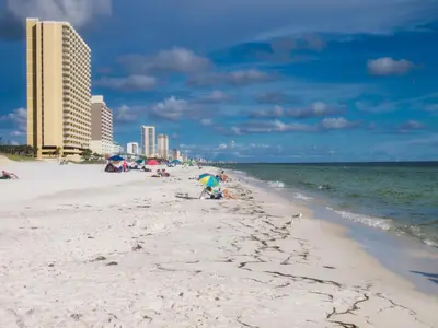 a group of people on a beach near the ocean at Tropic Winds 1901 in Panama City Beach