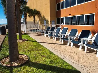 a row of lounge chairs in front of a building at Tropic Winds 1901 in Panama City Beach