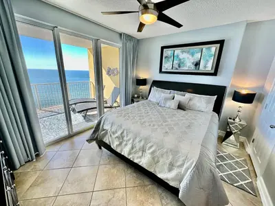 a bedroom with a bed with a view of the ocean at Tropic Winds 2002 in Panama City Beach