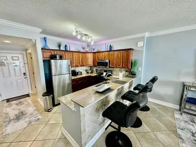 a kitchen with a counter and a refrigerator at Tropic Winds 2002 in Panama City Beach