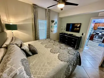 a bedroom with a bed and a flat screen tv at Tropic Winds 2002 in Panama City Beach