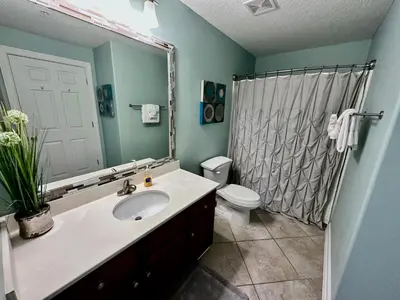 a bathroom with a sink and a toilet and a shower at Tropic Winds 2002 in Panama City Beach