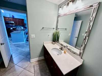 a bathroom with a sink and a large mirror at Tropic Winds 2002 in Panama City Beach