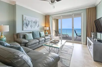 a living room with a couch and a glass table at Ocean Reef 1101 in Panama City Beach