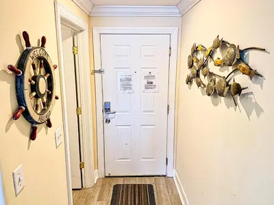 a white door with a clock on the wall at Tropic Winds 801 in Panama City Beach
