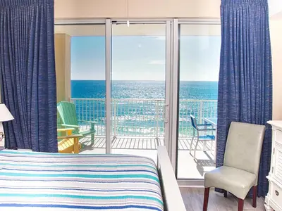 a bedroom with a bed and a view of the ocean at Tropic Winds 801 in Panama City Beach