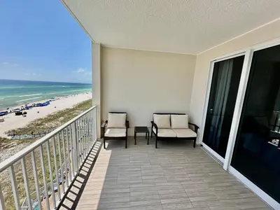 a balcony with two chairs and a view of the beach at Ocean Reef 604 in Panama City Beach