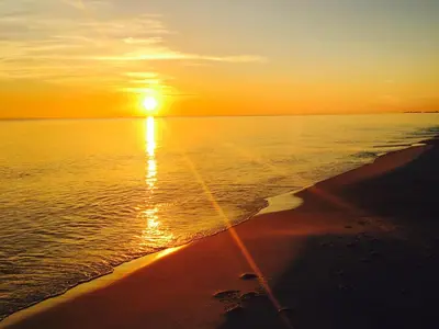 a sunset on the beach with the sun setting at Ocean Reef 604 in Panama City Beach