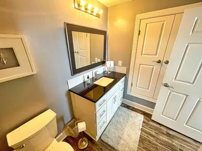 a bathroom with a sink and a toilet and a mirror at Tropic Winds 1604 in Panama City Beach