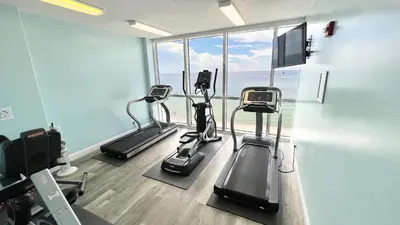 a gym with three tread machines in a room at Tropic Winds 1604 in Panama City Beach
