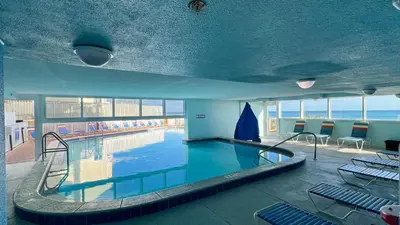 a large swimming pool in a building with chairs at Tropic Winds 1604 in Panama City Beach