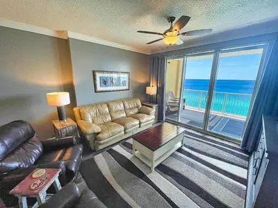 a living room with a couch and a view of the ocean at Tropic Winds 1604 in Panama City Beach