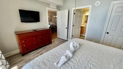 a bedroom with a bed and a tv and a dresser at Tropic Winds 1609 in Panama City Beach