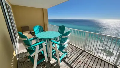 a table and chairs on a balcony with the ocean at Tropic Winds 1609 in Panama City Beach