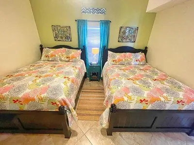 two beds sitting next to each other in a bedroom at Tropic Winds 1406 in Panama City Beach