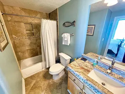 a bathroom with a toilet and a sink and a shower at Tropic Winds 1406 in Panama City Beach
