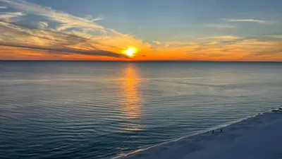a sunset over the ocean with the sun reflecting in the water at Ocean Reef 1308 in Panama City Beach