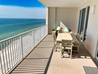 a balcony with a table and chairs and the ocean at Ocean Reef 1308 in Panama City Beach