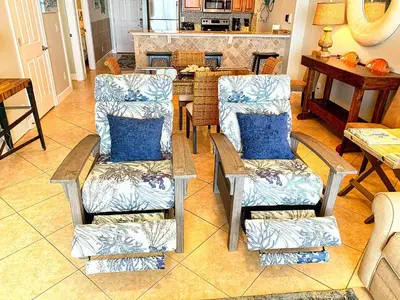 a living room with two chairs and a table at Ocean Reef 1604 in Panama City Beach