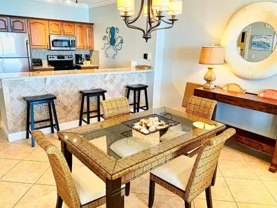 a kitchen and dining room with a table and chairs at Ocean Reef 1604 in Panama City Beach