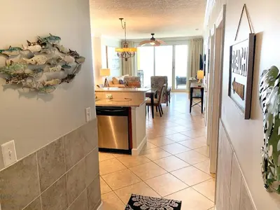 a living room with a kitchen and a dining room at Ocean Reef 1604 in Panama City Beach