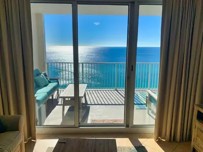 a room with a balcony with a view of the ocean at Ocean Reef 1604 in Panama City Beach