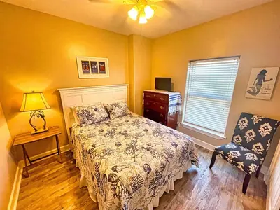a bedroom with a bed and a dresser and a window at Ocean Reef 1401 in Panama City Beach