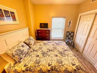 a bedroom with a bed and a dresser and a window at Ocean Reef 1401 in Panama City Beach