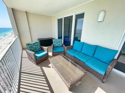 a patio with a couch and chairs on a balcony at Ocean Reef 1401 in Panama City Beach