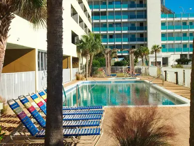 a swimming pool with lounge chairs and a building at Ocean Reef 1401 in Panama City Beach