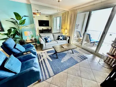 a living room with a blue couch and a table at Ocean Reef 1402 in Panama City Beach