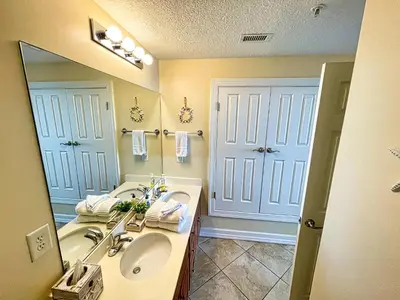 a bathroom with two sinks and a large mirror at Ocean Reef 1402 in Panama City Beach
