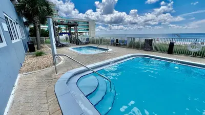 a swimming pool with the ocean in the background at Ocean Reef 1402 in Panama City Beach