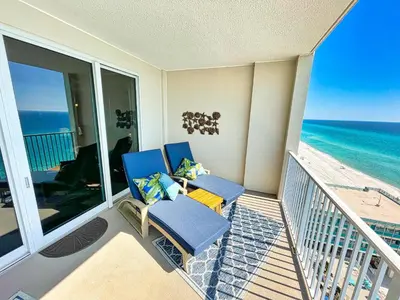 a balcony with two blue chairs and the ocean at Ocean Reef 1402 in Panama City Beach