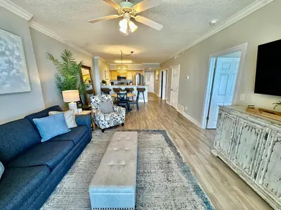 a living room with a blue couch and a table at Ocean Reef 1107 in Panama City Beach