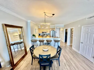 a dining room and kitchen with a table and chairs at Ocean Reef 1107 in Panama City Beach