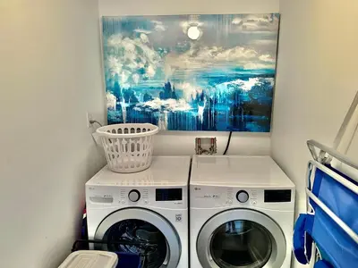 a laundry room with two washing machines and a painting at Ocean Reef 1107 in Panama City Beach