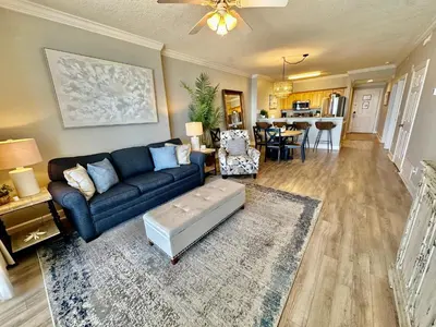 a living room with a blue couch and a table at Ocean Reef 1107 in Panama City Beach