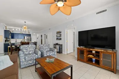 a living room with a large flat screen tv at Tropic Winds 1903 in Panama City Beach