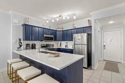 a kitchen with blue cabinets and a white counter top at Tropic Winds 1903 in Panama City Beach