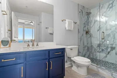 a bathroom with a toilet and a sink and a shower at Tropic Winds 1903 in Panama City Beach