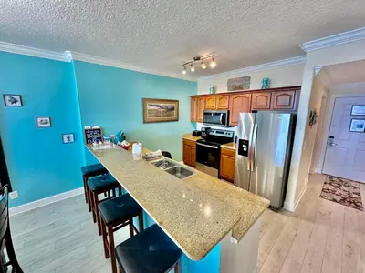 a kitchen with a counter top and a refrigerator at Ocean Reef 1007 in Panama City Beach