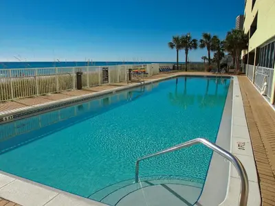 a large swimming pool with the ocean in the background at Ocean Reef 1007 in Panama City Beach