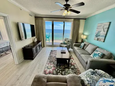 a living room with a couch and a tv at Ocean Reef 1007 in Panama City Beach